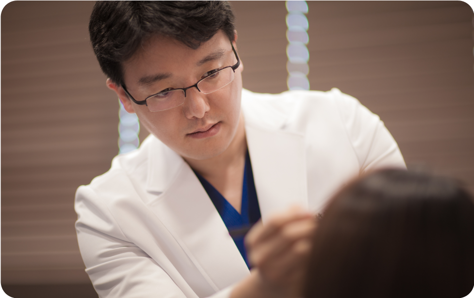 医師が患者の頭皮を診察している様子