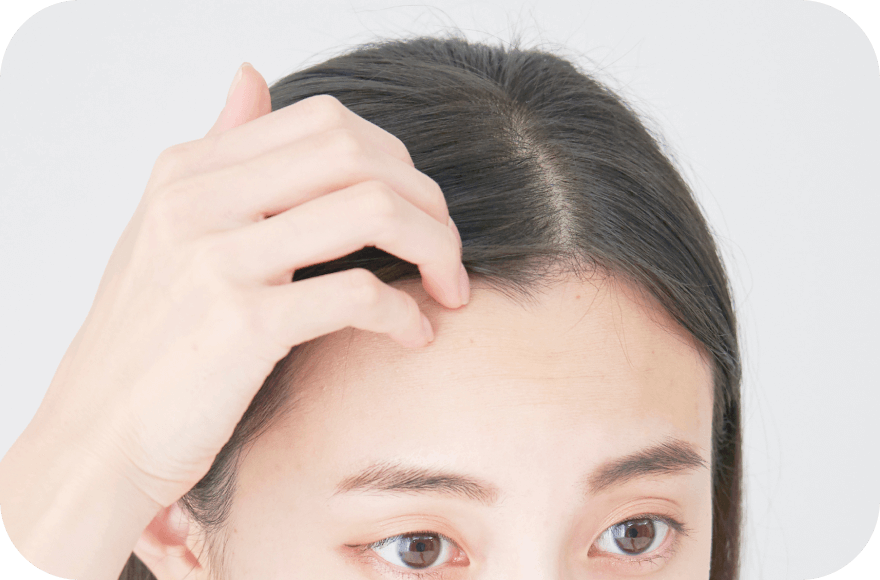 眉毛を手で整えている女性